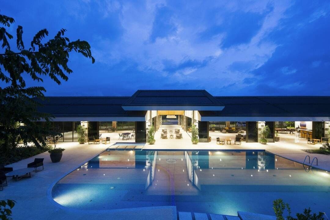 Piscine d'un hôtel de luxe illuminée la nuit, bien géré en location saisonnière